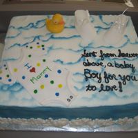 Baby Boy yellow butter cake, bc icing, airbrushed sky, fondant onies and booties, chocolate duck and bottle. The was a last minute cake. But it was...
