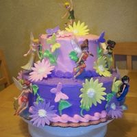 Disnay Fairies two tiered cake covered in buttercream, Fondant butterflies and flowers, disney fairies purchased at the disney story
