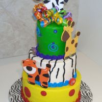 Jungle Birthday All buttercream with wooden animals and curly ribbon.
