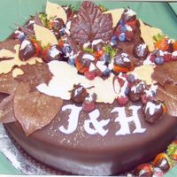 Romance In Chocolate Chocolate fondant covered cake with gold dusted hand made chocolate leaves in white, milk and dark chocolate. Chocolate dipped strawberries...