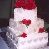 My Valentine Love 3 tier, square Valentine's Day wedding cake. Middle layer embossed and entirely dusted with Satin Silver petal dust. Fondant, Satin...