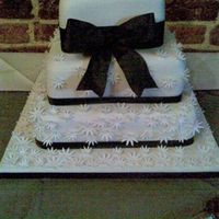 Black & White Wedding White fondant daisy decorations with black ribbon.Sorry about the awful photo it was taken on my mobile with no flash