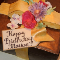 Gift Box This cake was covered with milk chocolate and fondant and gumpast flowers were added. Copper luster dust was added to add a sheen to the...