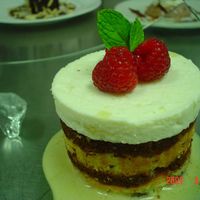 Imperial Apple Cake Chocolate and almond cake wrapped around chocolate mousse, sauteed apples and apple mousse. Cinnamon sauce, raspberries and mint top it off...