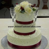 Bride On A Budget All buttercream, 12", 8", and 6". Satin ribbon and silk flowers. Silver dragees to accentuate scrollwork and second tier.