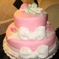 Pink Baby Shower Cake With Ribbons And Rattle cake covered in fondant, all decorations are fondant