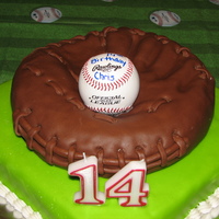 Son's 14Th Birthday Cake Glove is made out of a round cake, carved covered in chocolate fondant. Base is vanilla pound cake covered in marshmellow fondant.