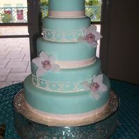 Tiffany Tower Almond cake covered with homemade fondant. Fresh orchids and royal icing design. Thanks for looking!