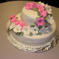 Two Tiered Floral Cake Royal Icing flowers on top of marshmallow fondant.