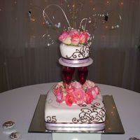 My Boss's Anniversary Cake this is white cake with rolled fondant. top layer is sitting on reall champagne flutes filled with wine. there are silver dragees on each...