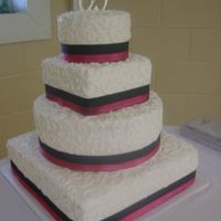 Janna's Cake Butterpecan and French Vanilla Cake with Buttercream icing. Freehand scrollwork. BubbleGum Pink and black ribbon around square and round...