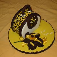 Handbag-Animal Skin Made a round fruit cake and cut off a piece to sit it flat on board. Covered fruit cake with a thin fondant coating which helps the final...