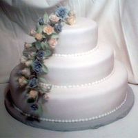 Cascade Of Roses Fondant covered 16, 12, & 8" tiers with buttercream filling. Gum paste roses