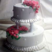 Tiered W/ Roses This cake is covered in fondant with a butter cream ruffled border. The roses are all fondant/gumpaste blend.