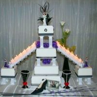 Square Formal Wedding Cake With Stairs Elegant 4-tier square wedding cake with stairs leading down to 2 satelite cakes adorned by black ribbons and purple African violets