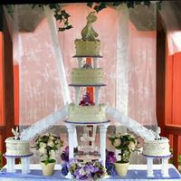 Emma's Simplicity Simple but elegant garden wedding cake featuring a fountain and white stairs. The cake boards are coved in purple florist paper to accent...