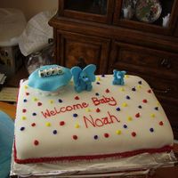 Baby Shower Dark Chocolate cake covered in MMF. Two different size elephants made out of fondant. The blue blanket sits upon a white favor box with...