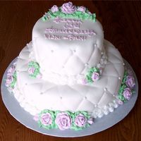 60Th Anniversary Cake 6" and 10" round covered in SatinIce with mauve buttercream roses. This was my first time completely covering a cake with fondant...