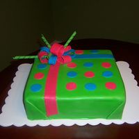 Birthday Gift Cake Chocolate cake frosted in chocolate buttercream frosting and coveredin fondant with fondant accents.