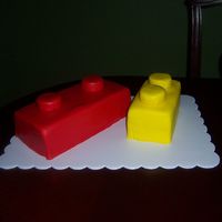 106_6299.jpg Yellow cake with buttercream frosting and covered in fondant. Top pieces of the legos are rice krispy treats wrapped in fondant.