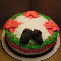 Poinsetta Wreath Cake All buttercream except the pine cones are mini cream horn shells with ganache piped petals, bottom border is also ganache. Candy cane...