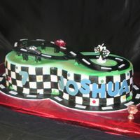 Joshua 7 Birthday cake for a good friend's seven year old son. Cake is covered in marshmallow fondant, letters and tracks are fondant. The...