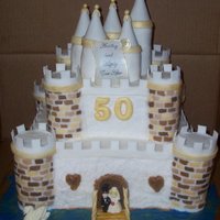 50Th Anniversary Castle I made this for a state fair competition. The castle and towers is all cake. The spires on top are covered in fondant and brushed w/ gold...