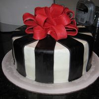 Black Stripes With Bow Cake is iced in buttercream with black fondant stripes. The bow is gumpaste