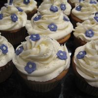 Flower Cupcakes Cupcakes iced in buttercream with purple fondant flowers and edible glitter.