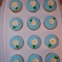 Summer Cupcakes 2 French vanilla cupcakes with wedding icing. Flowers are gum paste and leaves are fondant. I made this for a work social.