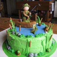 Fishing Birthday Cake 9" round cake with buttercream icing. Fondant fisherman, boat, and other decorations. Fish is gum paste. Thank you for the inspiration...