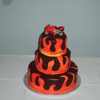 Motorcycle And Flames Chocolate ganache glazed grooms cake with fondant flames and die cast Ducati model of the groom's motorcycle as topper.