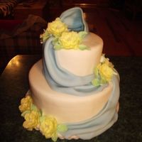 Ribbons And Posies Fondant covered, two tier cake. 6 & 10" layer cakes.Fondant drapes and gum paste Posies.