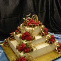 Golden Anniversary Iced in buttercream, with buttercream roses and sugar bells. Was asked to come up with a design for a customer using Red and Gold. This is...