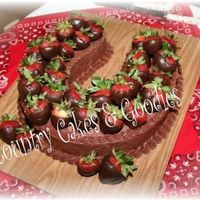 Horseshoe Groom's Cake With Chocolate Covered Strawberries This is a 2 layer chocolate horseshoe cake with chocolate buttercream icing and chocolate covered strawberries. I also covered the board...