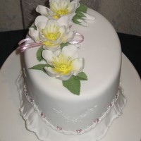 Ribbon Insertion Oval fruit cake covered in almond icing then fondant, gumpaste fantasy flowers and frill, royal icing embroidery and real ribbon used in...