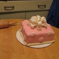 Present_Cake.jpg Just a random cake I did, pink fondant, white fondant bow w/ glitter...:) Ignore the buttercream at the bottom, it was just for the pic...
