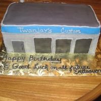 Img_0209.jpg First attempt at a building. This cake was for a co-worker whose husband was opening an auto body shop. Simple building with black fondant...