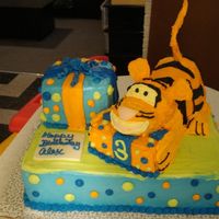 Dsc00630.jpg Tigger cake and present cakes on sheet cake. Tigger's head is rice crispy treats, the restis cake and icing.