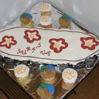 Luau Cupcakes Surfboard cupcake cake , with palm trees and flowers on extra cupcakes. The sand is crushed graham crackers. Palm tree and flowers inspired...