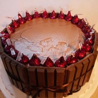 Kit Kat Kisses Barrel 8" 4-layer cake, butter almond flavor filled and iced with chocolate SMBC. Covered with Kit Kats and top decorated with Cherry Cordial...