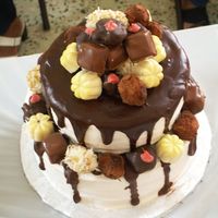 Chocolates Tower Tow tier of almond flavored cake with fresh strawberry filling, covered in buttercream and chocolate ganache, then decorated with handmade...