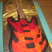 Guitar With Flames single layer cake, choc. buttercream tinted black, the neck is made out of rkt, I had problems with the neck had to put a piece of styfroam...