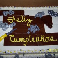 Screws this is a white cake with whipped topping frosting and MMF accents. It's screws, hexnuts, and washers sitting on wooden floor boards...