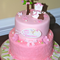 Little Girls Love Ribbons And Pearls cake designed after crib linen. It had a tree with flowers and a love bird. It was pink, green and white.