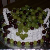 Basket Of Grapes This cake was for a friend who loves vineyards. It is a 2 layer 8" round with BC basketweave, Fondant handles, and real grapes. It was...