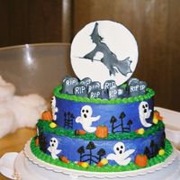 Halloween Graveyard I did the two tiers in devil's food cake covered with buttercream icing. The witch in the moon and the tomb stones are color flow.
