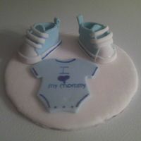 Cake Top converse shoes, and onsie made from gum paste and fondant going on top of cake