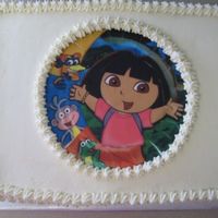 Dora 9x13 yellow cake with cream cheese frosting and an edible image of Dora made from the party plates.