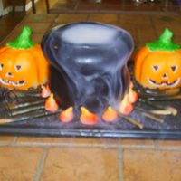 Halloween Cake - Boiling Cauldron And Jack-O-Lanterns This is a chocolate cake with vanilla buttercream frosting. The "dirt" is crushed Oreos. The wood and flames are rolled fondant...